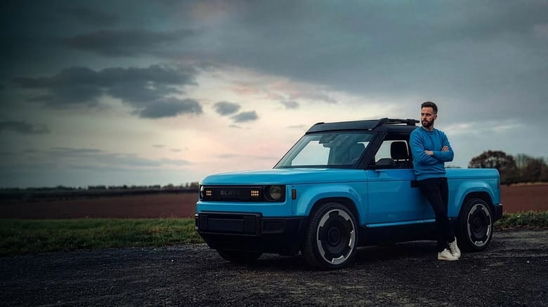 Человек стоит рядом с электрическим пикапом Slate Truck на улице Человек стоит рядом с электрическим пикапом Slate Truck на улице