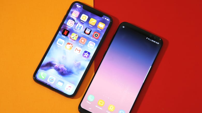 iPhone X и Samsung S8+ лежат рядом на столе iPhone X и Samsung S8+ лежат рядом на столе
