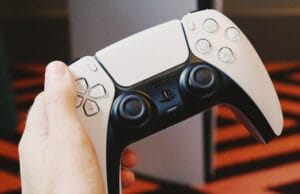 Срок службы и автономность игрового контроллера PlayStation 5 DualSense Мужчина держит геймпад для PS5