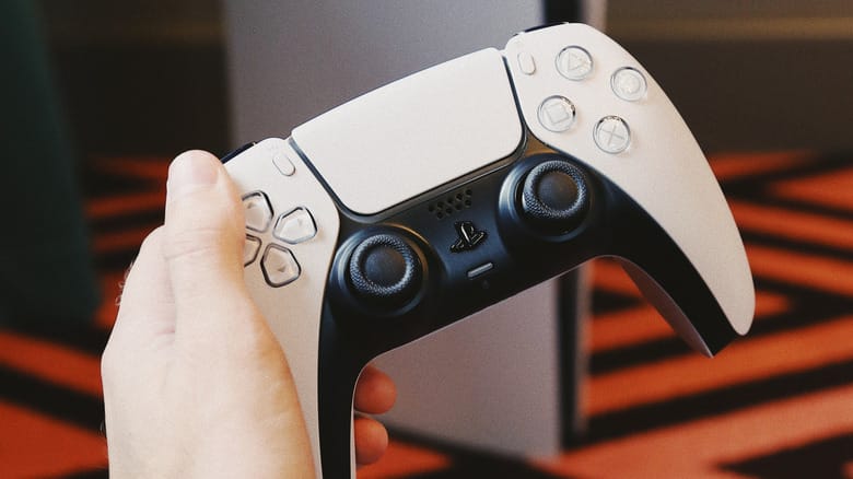 Мужчина держит геймпад для PS5